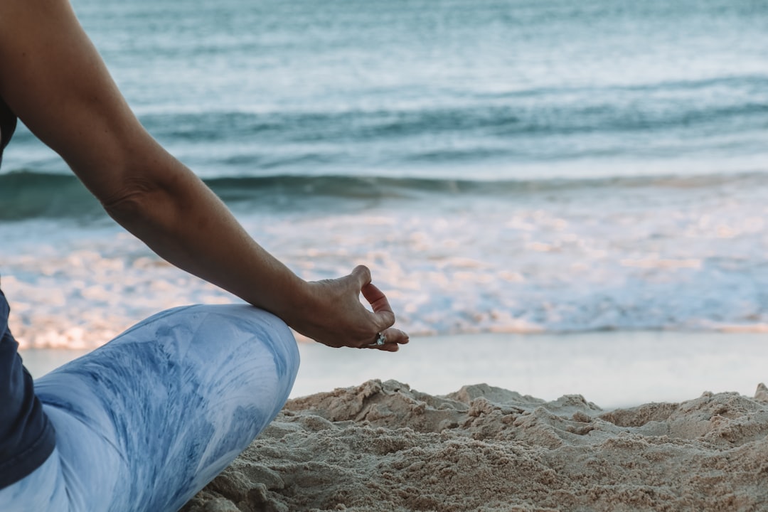 person-in-blue-shorts-sitting-on-beach-shore-during-daytime-n8l1vyaypcw